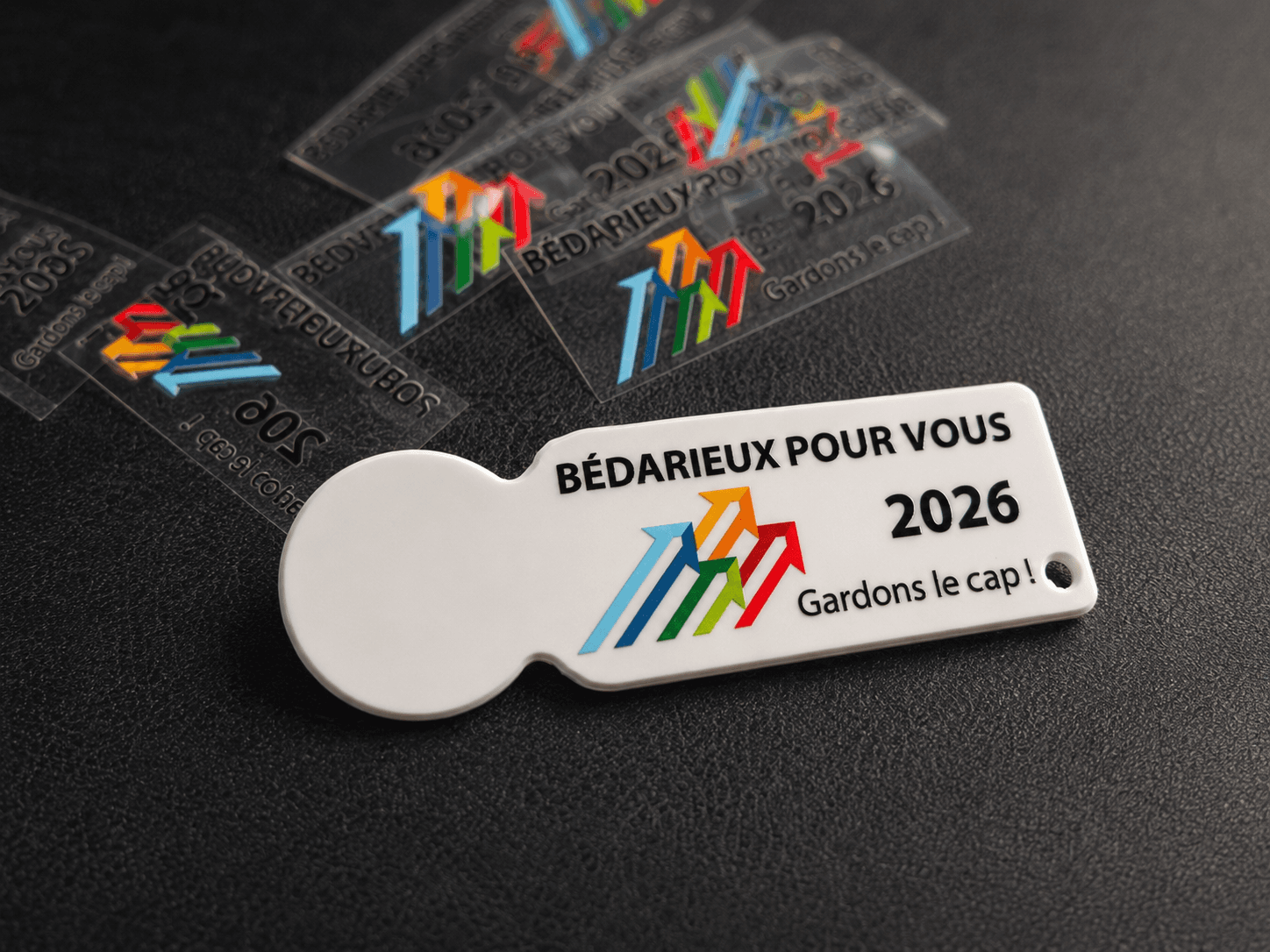 Gros plan d'un jeton de caddy PVC floqué en UV DTF aux couleurs de la campagne Bédarieux Pour Vous 2026