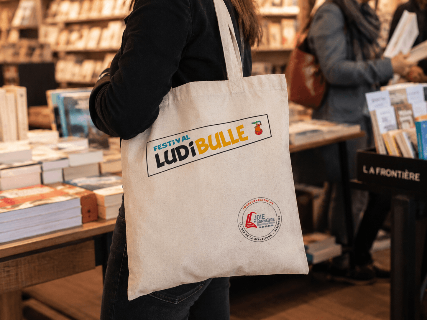 Tote bag coton LudiBulle avec le tampon de la librairie Joie de Connaître, mis en scène
